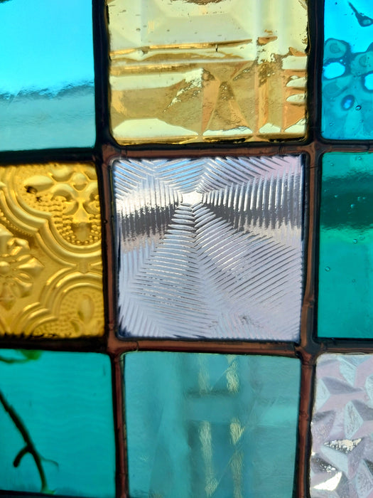 Timber framed patchwork in teal and yellow.