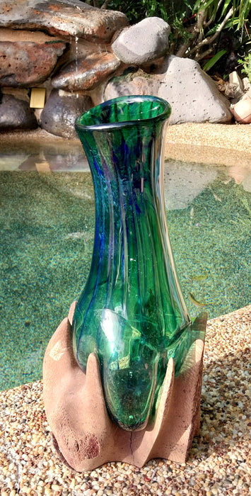 Molten teal blue and green mouthblown glass vase in timber stand.