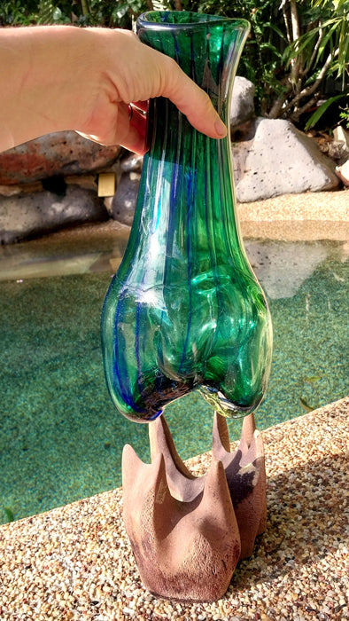 Molten teal blue and green mouthblown glass vase in timber stand.