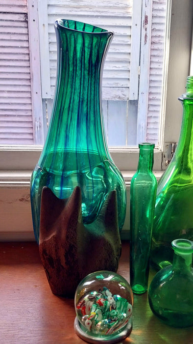 Molten teal blue and green mouthblown glass vase in timber stand.