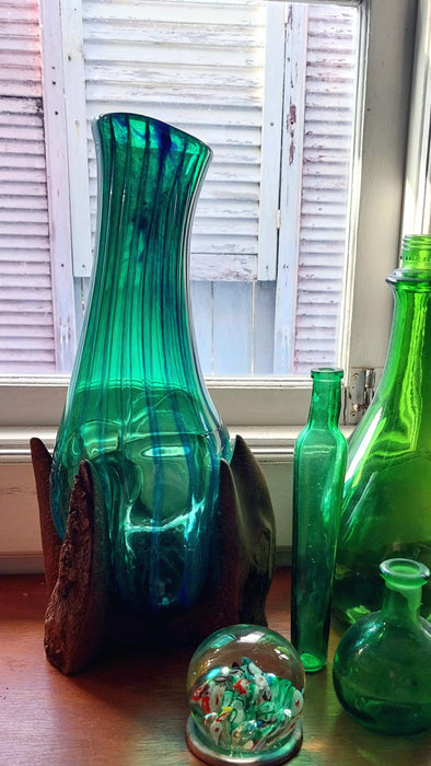 Molten teal blue and green mouthblown glass vase in timber stand.
